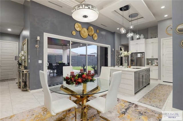 dining area featuring a towering ceiling, recessed lighting, baseboards, and a tray ceiling