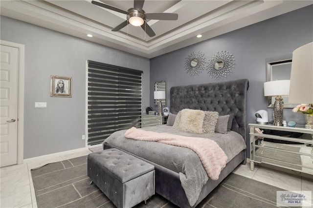 bedroom with a tray ceiling, recessed lighting, baseboards, and a ceiling fan