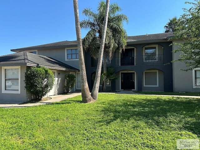 view of front of home featuring a balcony and a front lawn