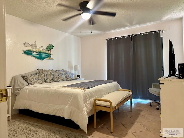 tiled bedroom featuring a textured ceiling and ceiling fan