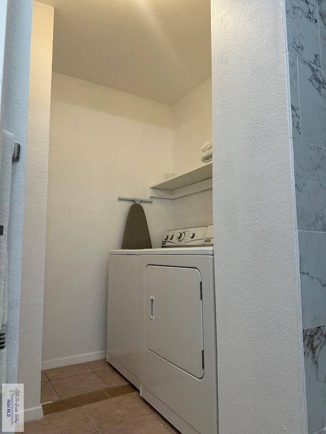 laundry area with light tile patterned flooring and washing machine and clothes dryer