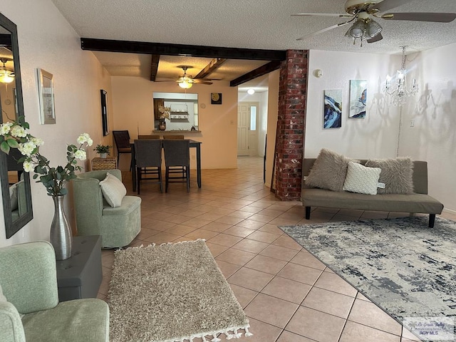 tiled living room with beamed ceiling, a textured ceiling, and ceiling fan with notable chandelier