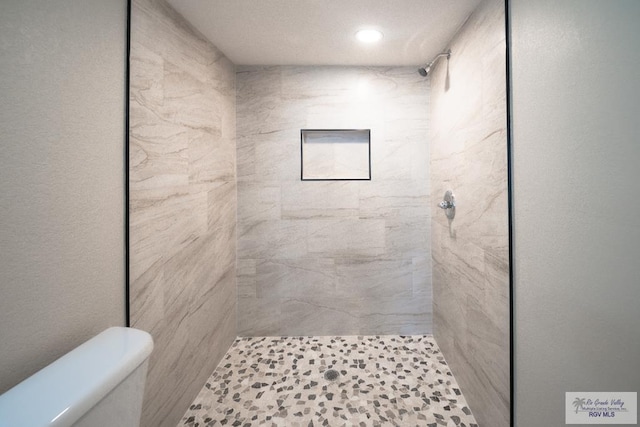 bathroom featuring toilet, a shower stall, and recessed lighting