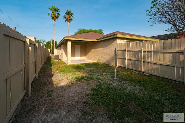 view of yard with a fenced backyard and central AC