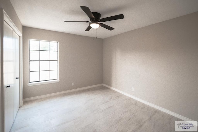 spare room with baseboards and ceiling fan