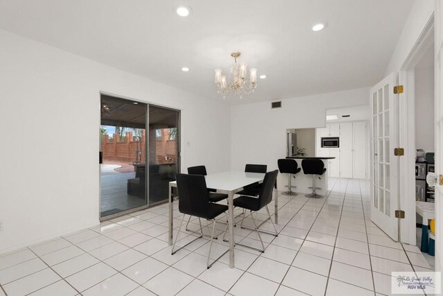 tiled dining space with a chandelier