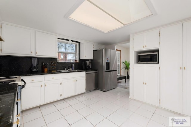 kitchen featuring white cabinets, stainless steel appliances, tasteful backsplash, and sink