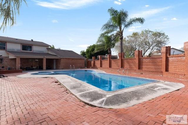 view of swimming pool with an in ground hot tub and a patio area