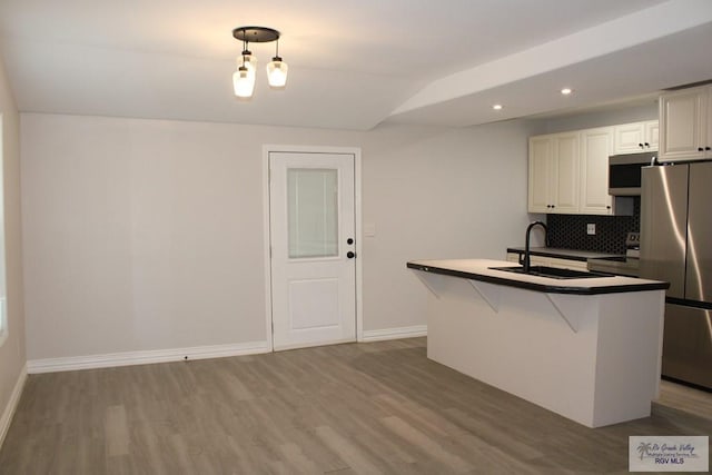 kitchen with white cabinetry, sink, hanging light fixtures, appliances with stainless steel finishes, and light wood-type flooring