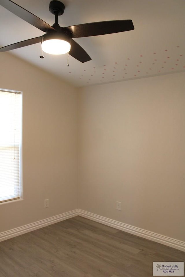 unfurnished room with ceiling fan and dark hardwood / wood-style flooring