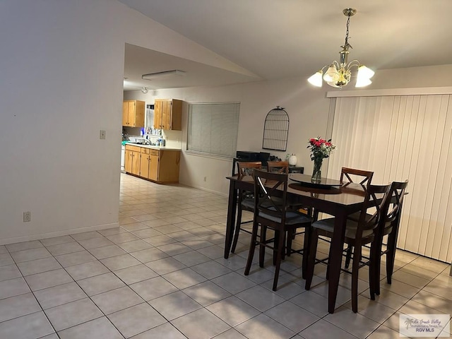 dining space featuring light tile patterned floors, an inviting chandelier, vaulted ceiling, and sink