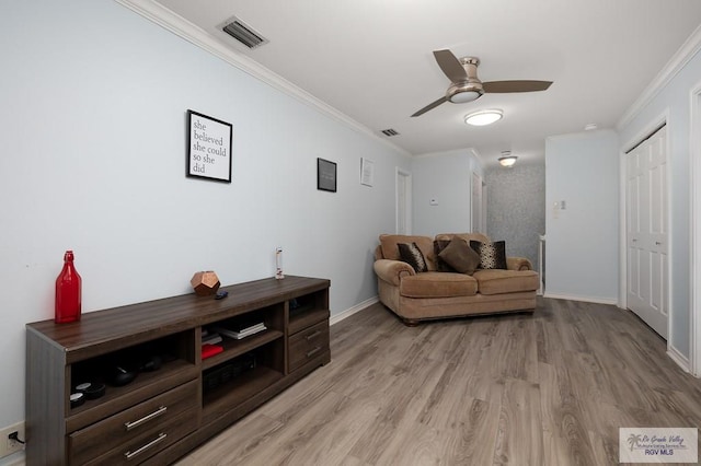 sitting room featuring light hardwood / wood-style floors, ceiling fan, and crown molding