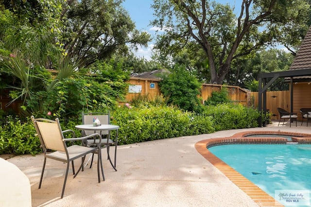 view of pool with an in ground hot tub and a patio