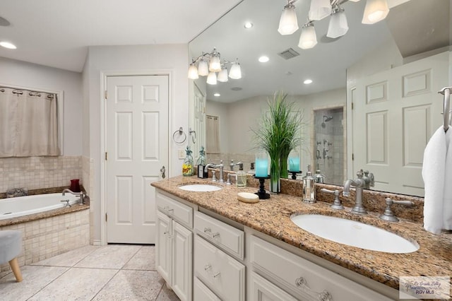 bathroom featuring plus walk in shower, vanity, and tile patterned floors