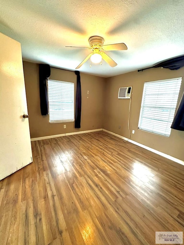 unfurnished room featuring hardwood / wood-style floors, plenty of natural light, ceiling fan, and a textured ceiling