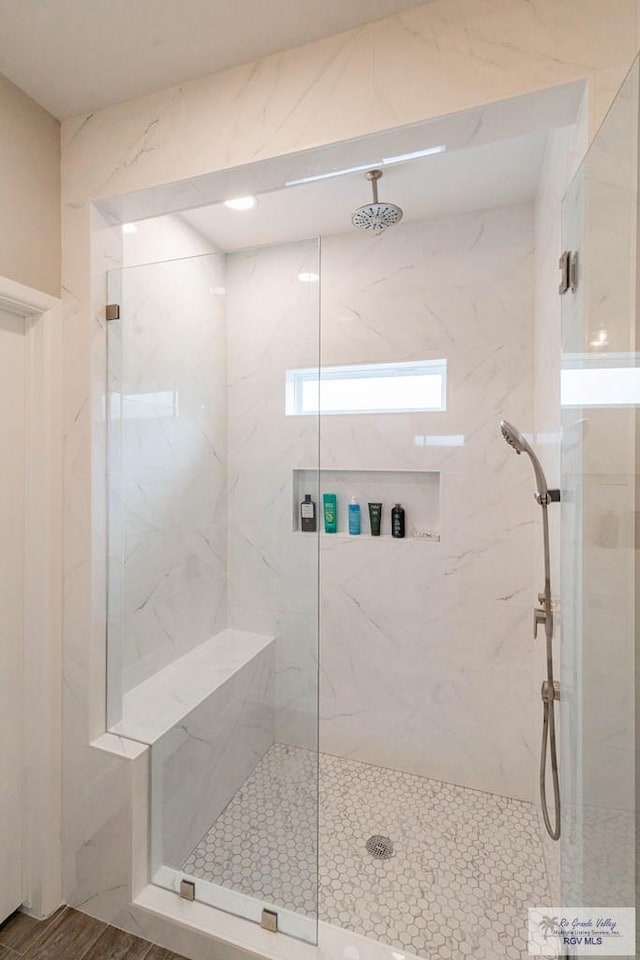 bathroom featuring a shower with door and hardwood / wood-style flooring