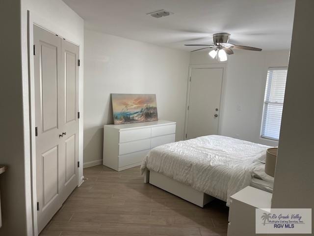 bedroom featuring ceiling fan, light hardwood / wood-style floors, and a closet