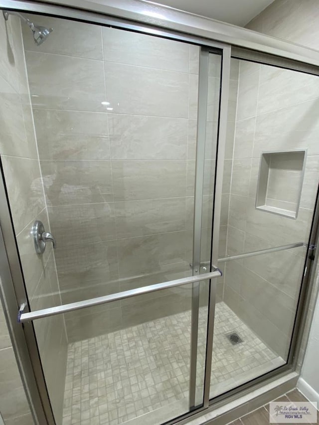 bathroom featuring a shower with door