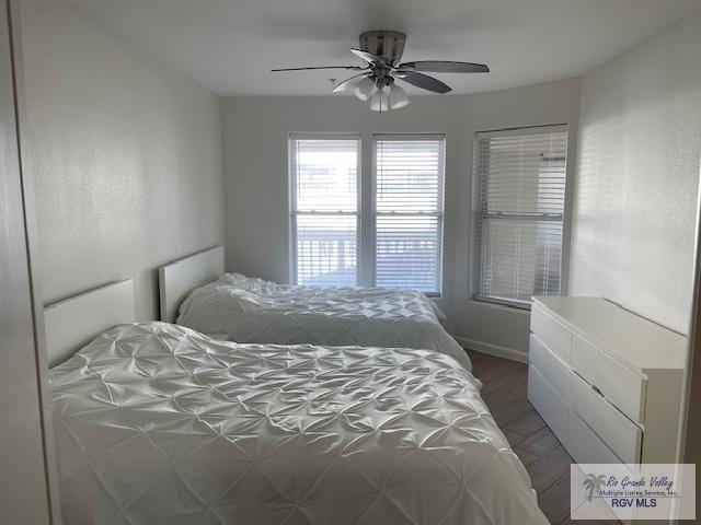 bedroom with ceiling fan and dark wood-type flooring