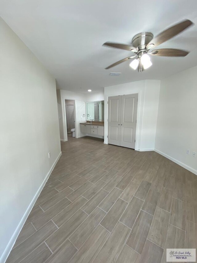 unfurnished living room featuring ceiling fan and light wood-type flooring