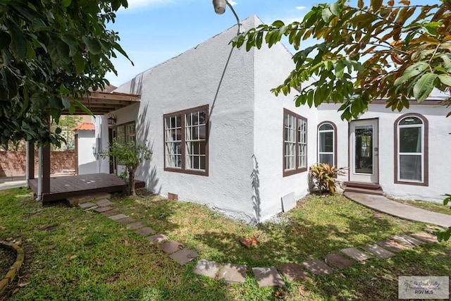 view of front facade featuring stucco siding and a front yard