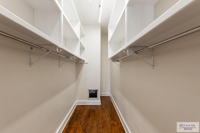 walk in closet with wood finished floors