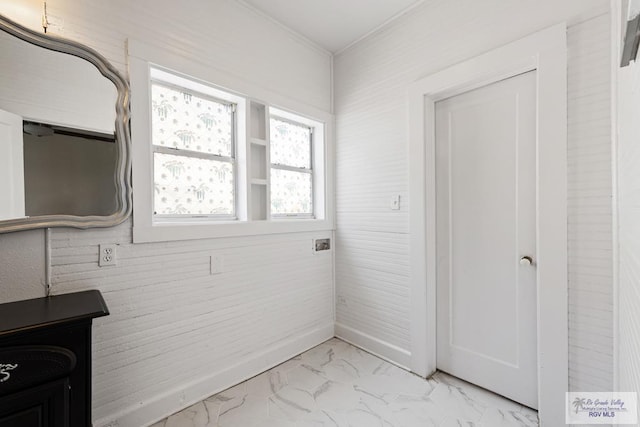 interior space featuring marble finish floor and ornamental molding