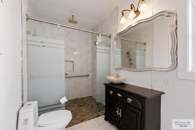 bathroom featuring vanity, toilet, and a marble finish shower