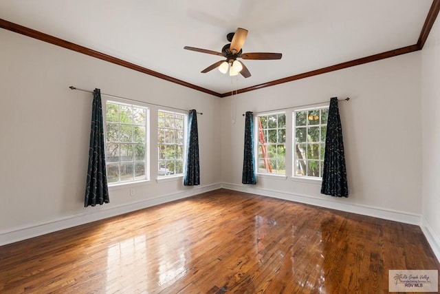 empty room with a ceiling fan, crown molding, baseboards, and hardwood / wood-style flooring