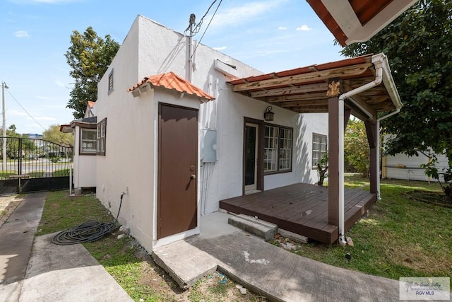 exterior space with a yard, fence, and stucco siding