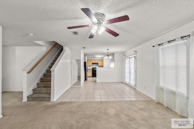 unfurnished living room with ceiling fan with notable chandelier, a textured ceiling, and light colored carpet