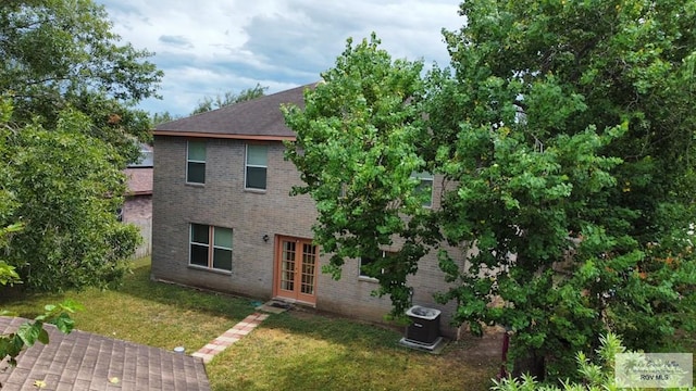 exterior space with a yard, french doors, and cooling unit