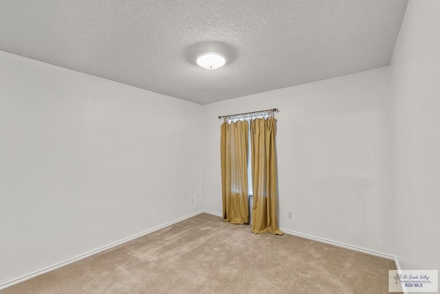 carpeted empty room featuring a textured ceiling