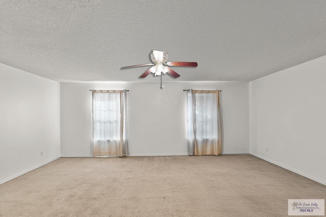 spare room with ceiling fan, light colored carpet, and a textured ceiling