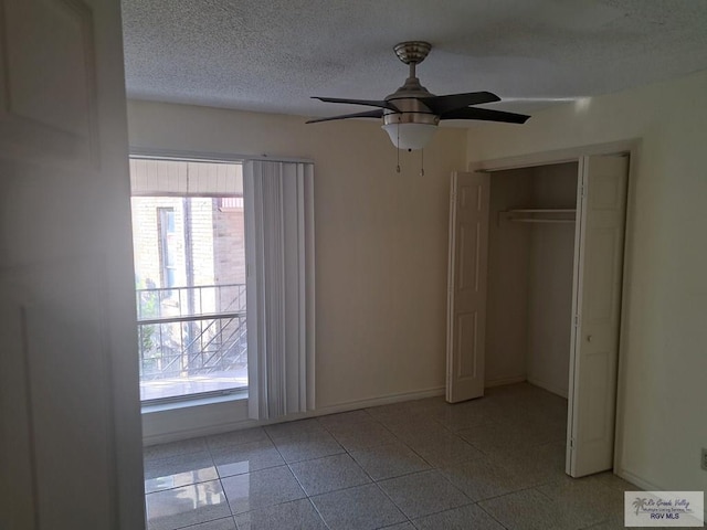 unfurnished bedroom featuring a textured ceiling, a closet, ceiling fan, and light tile patterned flooring