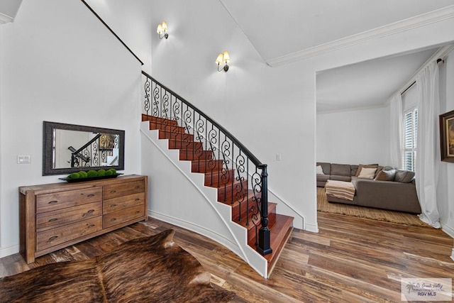 stairs featuring wood-type flooring and ornamental molding