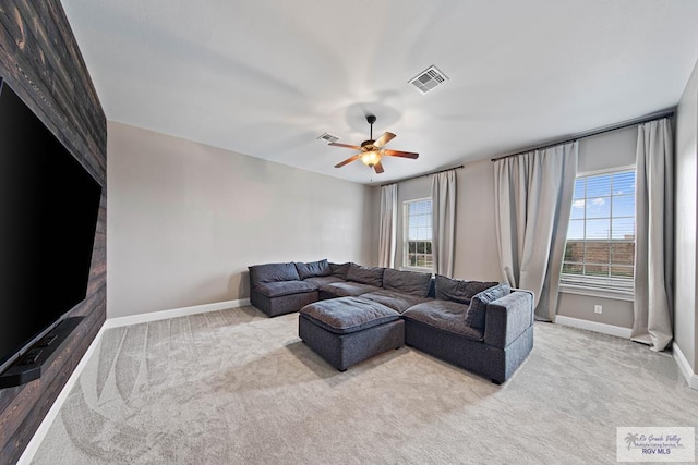 carpeted living room featuring a wealth of natural light and ceiling fan