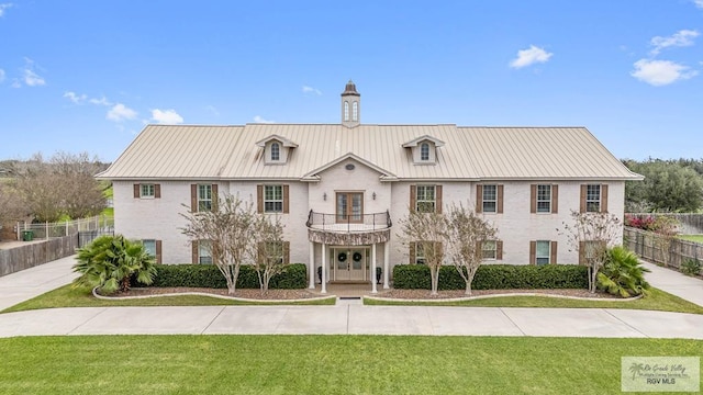 view of front of property featuring a balcony and a front yard