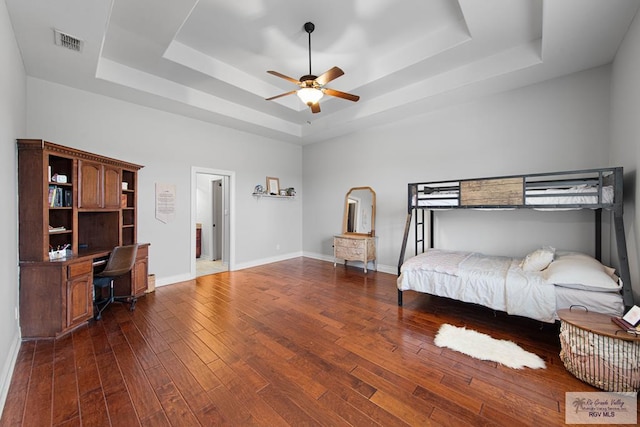 bedroom featuring a tray ceiling, ceiling fan, and dark wood-type flooring