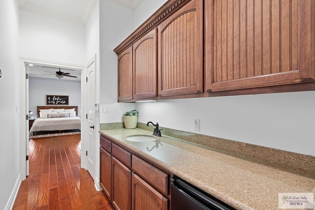 kitchen featuring dishwasher, dark wood-type flooring, sink, ceiling fan, and ornamental molding