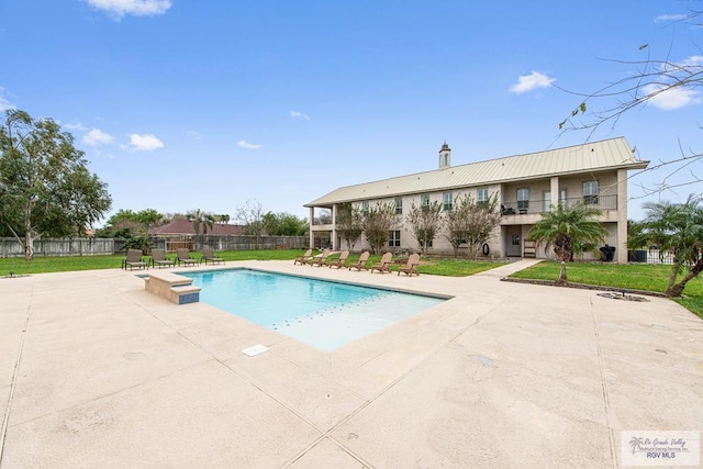 view of pool featuring a lawn and a patio