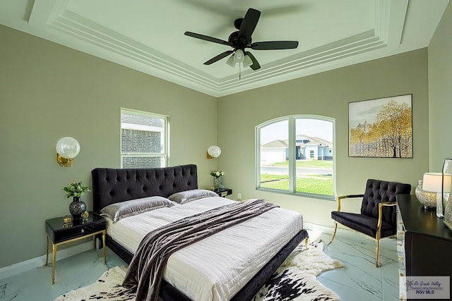 bedroom featuring marble finish floor, a tray ceiling, a ceiling fan, and baseboards