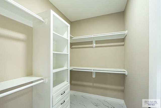 spacious closet featuring marble finish floor