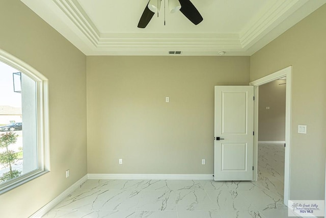 empty room with marble finish floor, baseboards, visible vents, and a raised ceiling