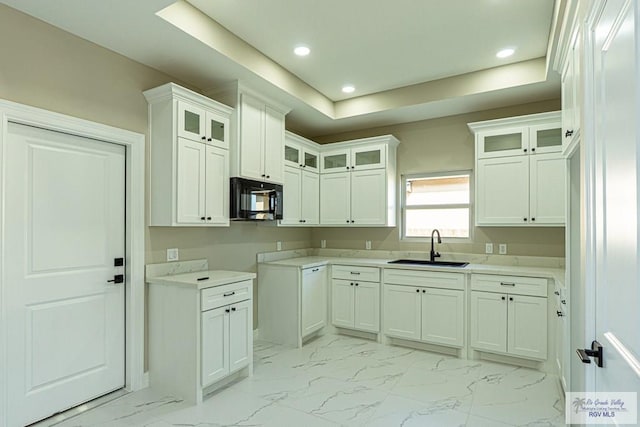 kitchen with white cabinets, glass insert cabinets, marble finish floor, black microwave, and a sink