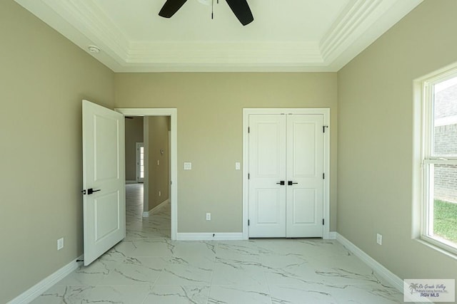 unfurnished bedroom with marble finish floor, multiple windows, and baseboards