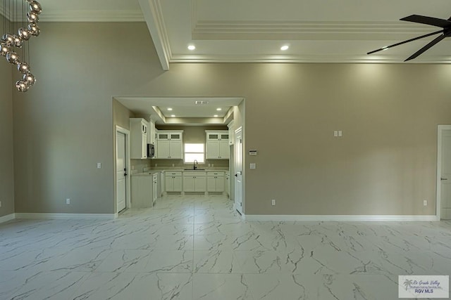 unfurnished living room featuring marble finish floor, a raised ceiling, a sink, and recessed lighting