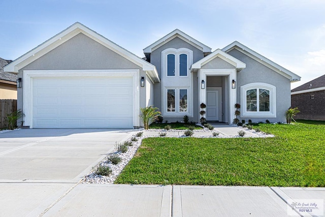 view of front of house with driveway, a front lawn, an attached garage, and stucco siding