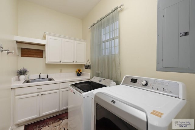 washroom with cabinet space, independent washer and dryer, electric panel, and a sink