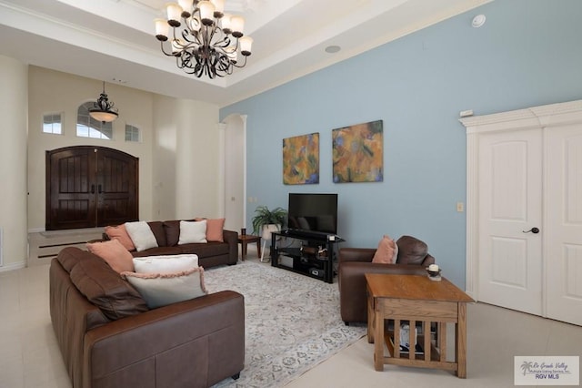 living area featuring a tray ceiling, visible vents, and an inviting chandelier